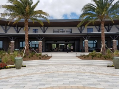 clubhouse with 2 large palm trees in front