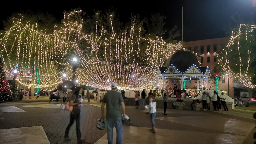 trees draped in lights with gazebo in background